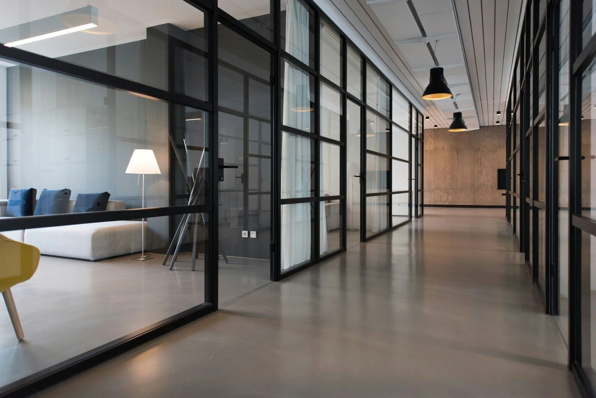 Orderly office corridor with glass meeting rooms and clean floors